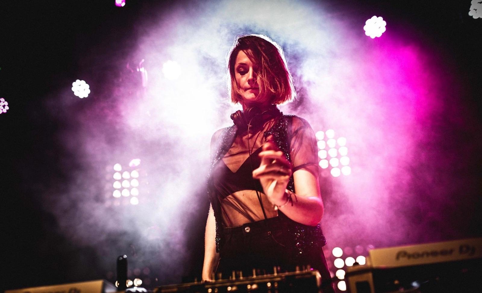 Gwladys Laplace playing live, bathed in pink stage light and smoke